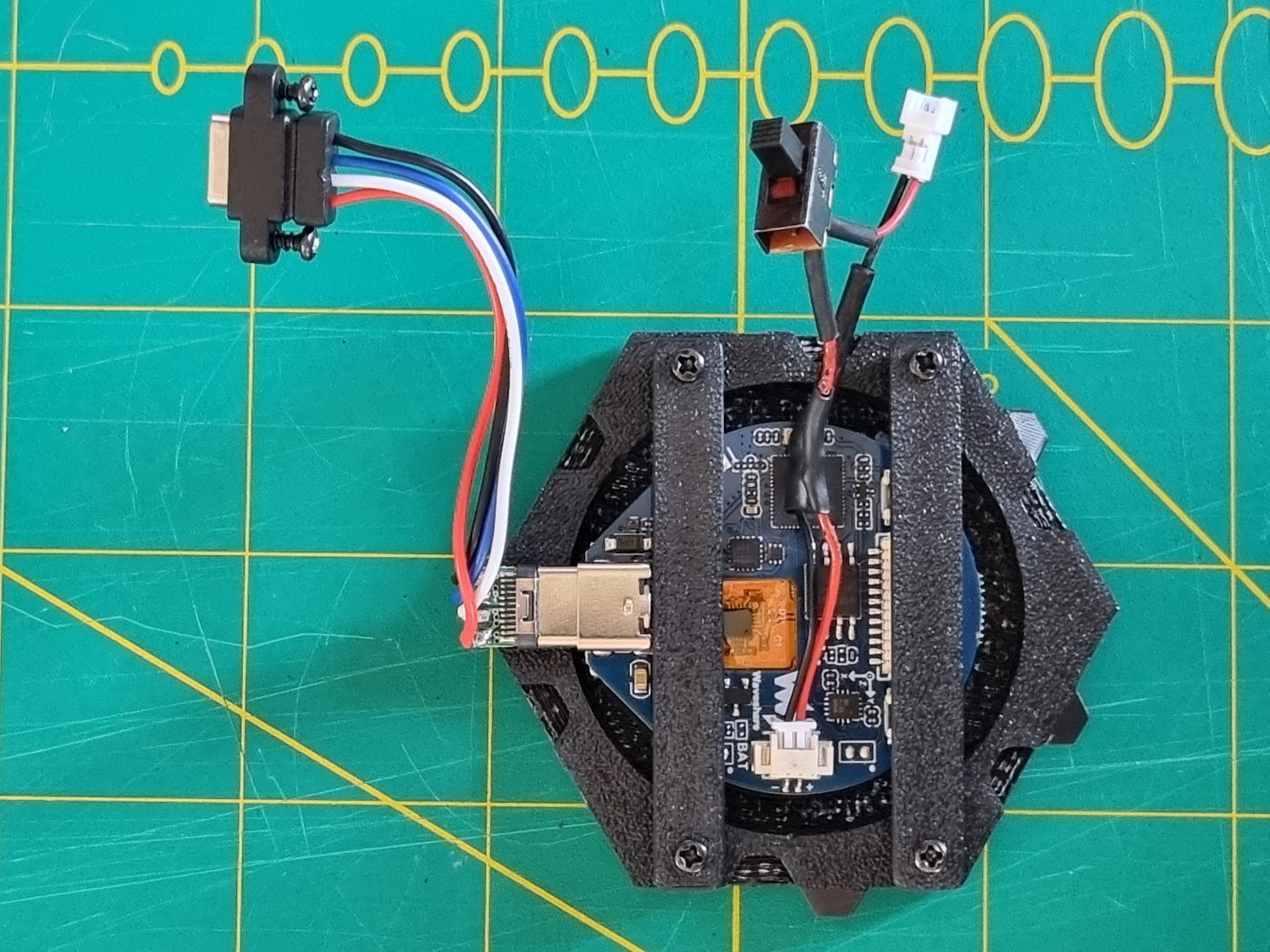 The ESP32-S3 board mounted in the hex screen body, seen from behind, held in place by the two retaining bars. Battery and USB connectors are also visible. The ESP32-S3 board mounted in the hex screen body, seen from behind, held in place by the two retaining bars. Battery and USB connectors are also visible.