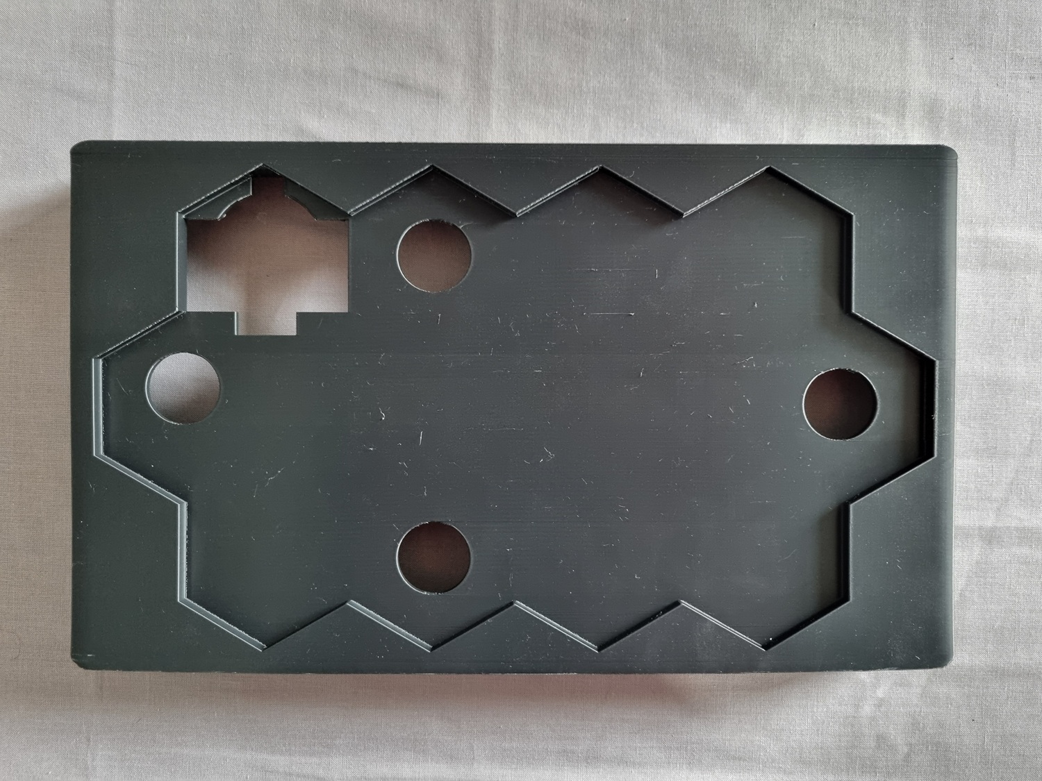 The top of the main enclosure, showing the indentation for the tile map and holes for LEDs and ESP32-S3 cabling to route behind. The top of the main enclosure, showing the indentation for the tile map and holes for LEDs and ESP32-S3 cabling to route behind.