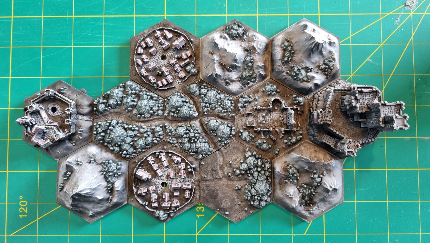 Top-down view of the fully-painted hex tile map sitting on a cutting mat. Top-down view of the fully-painted hex tile map sitting on a cutting mat.